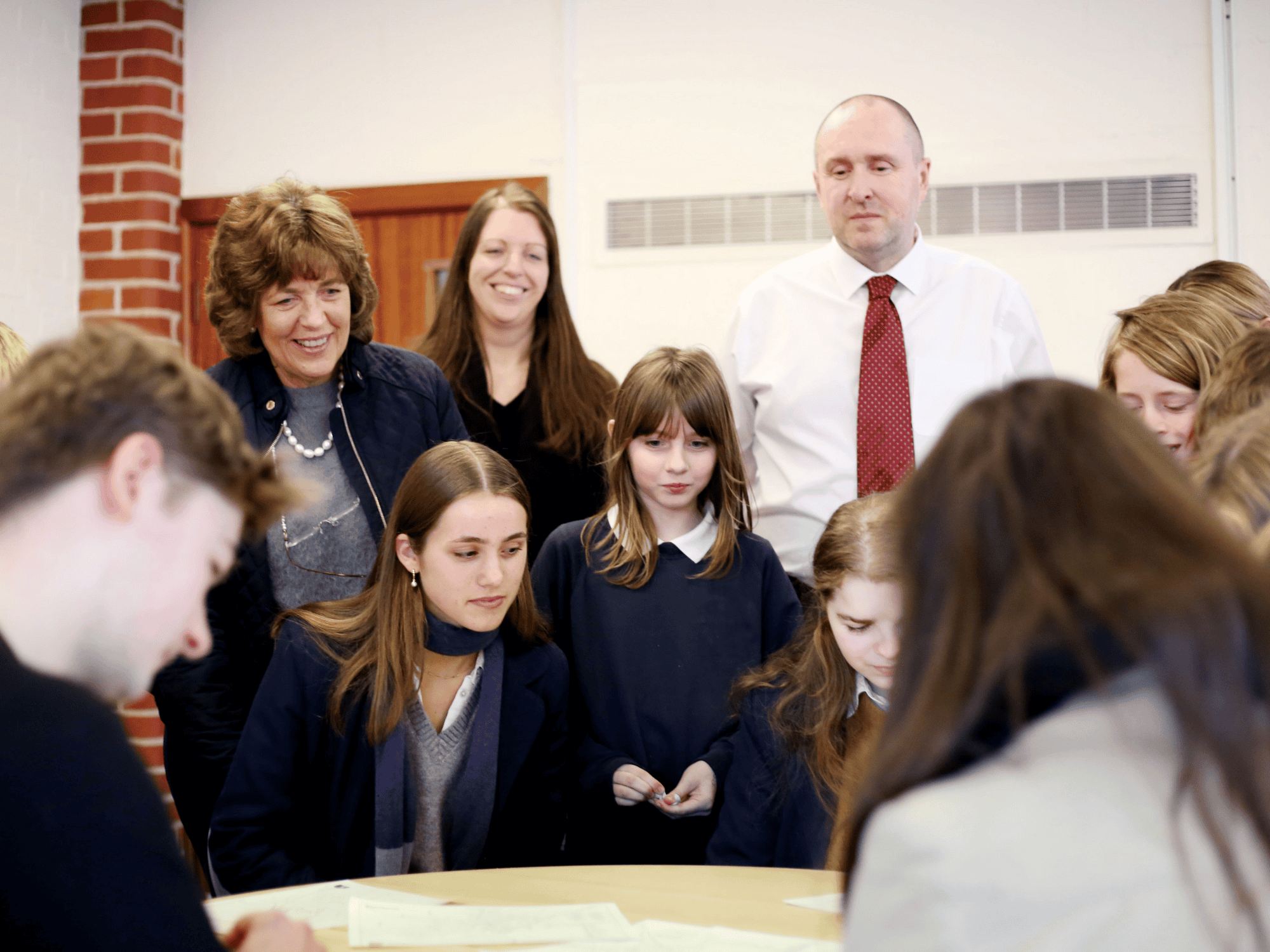 children and adults gathered round a table discussing