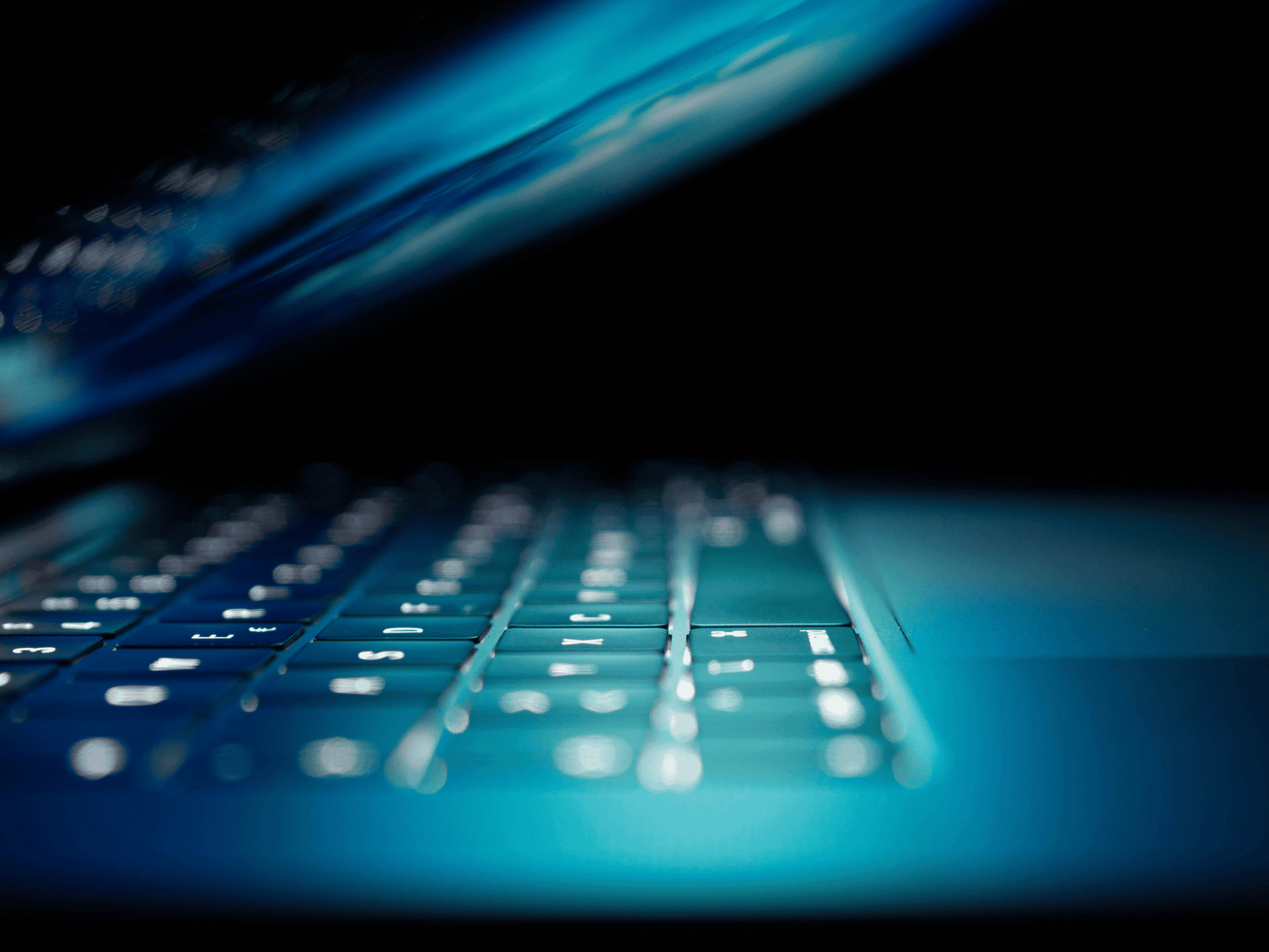 lit up laptop keyboard half closed