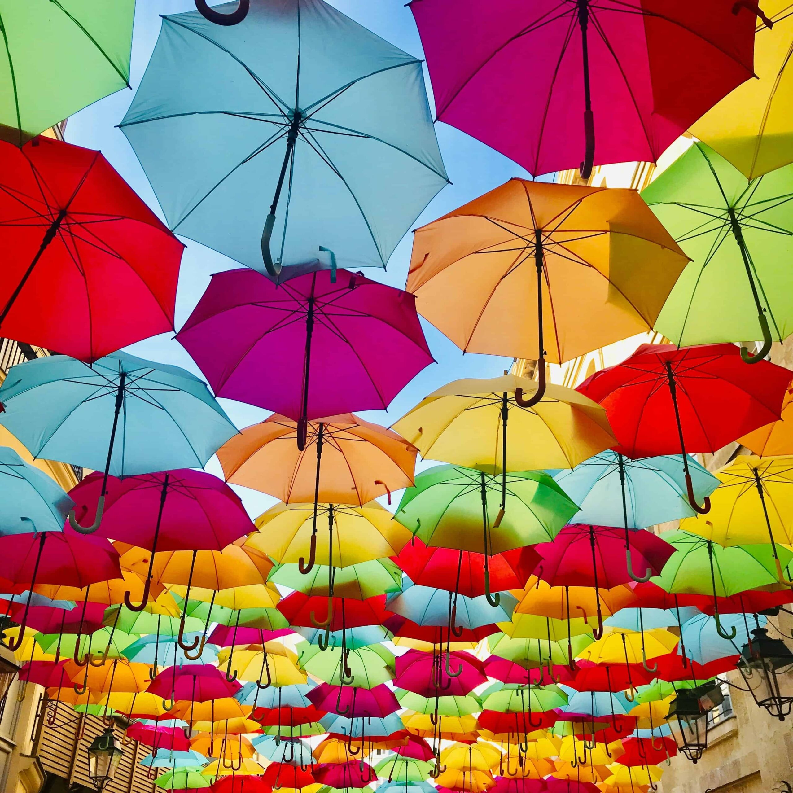 multiple umbrellas in different colours in the sky