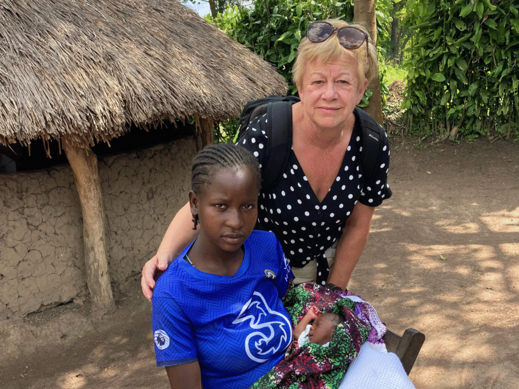 anne from sudan medical link with mother and her baby outside mud hut